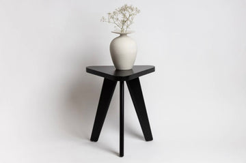 Chambers Design's KWH Side Table is a modern side table option for the home or office. It is a one-of-a-kind and stylish occasional table made of solid Beech wood, with graduated legs and a rounded triangular top.