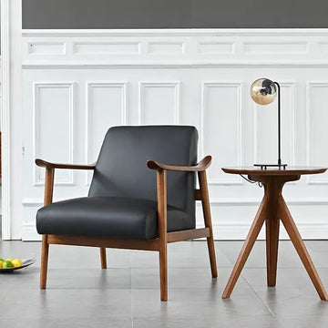 A sophisticated and charismatic statement chair, expertly crafted from leather and North American ash, with Walnut finish. Sculptured arms and wide, plush seat.